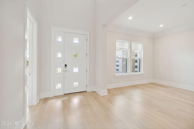 foyer with light wood-type flooring and crown molding