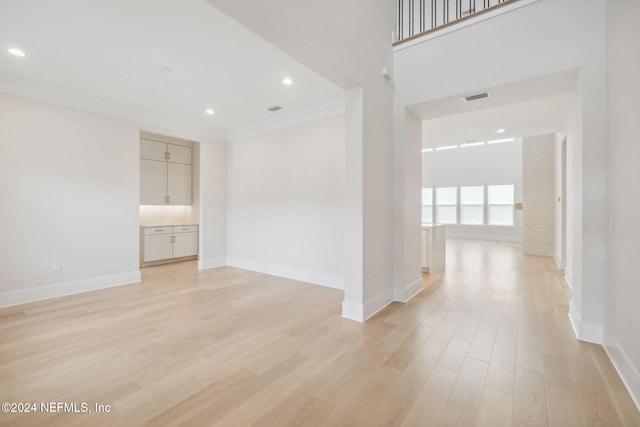 spare room featuring light wood-type flooring and ornamental molding