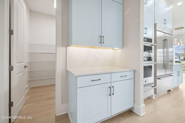 kitchen featuring appliances with stainless steel finishes, white cabinetry, and light hardwood / wood-style flooring