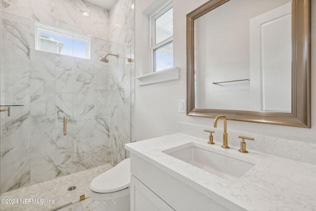 bathroom with vanity, a shower with shower door, and toilet