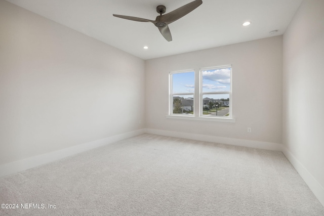 carpeted spare room featuring ceiling fan