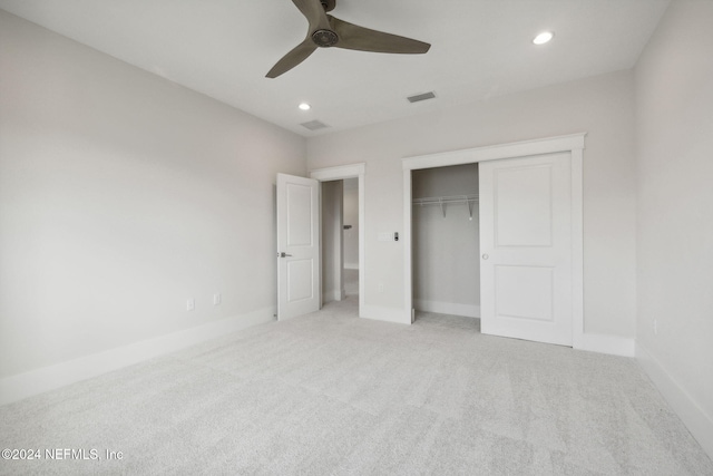 unfurnished bedroom with a closet, light colored carpet, and ceiling fan