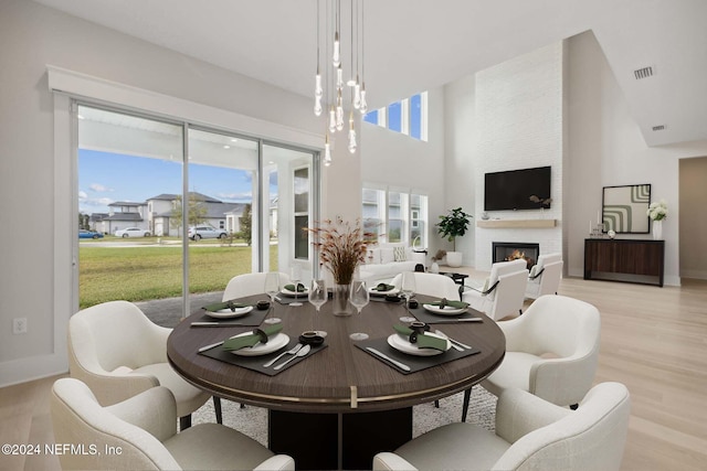 dining room featuring a large fireplace, plenty of natural light, and light hardwood / wood-style floors