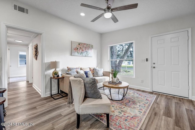 living room with ceiling fan and light wood-type flooring