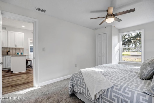 bedroom featuring ceiling fan, a closet, and dark carpet