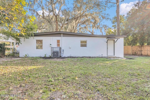 rear view of house featuring a yard and central AC unit