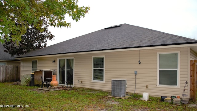 back of property featuring a yard and central AC unit