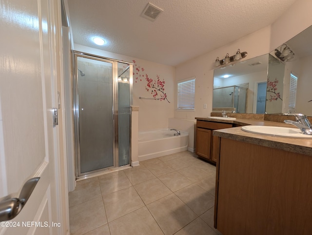 bathroom featuring tile patterned flooring, vanity, a textured ceiling, and independent shower and bath