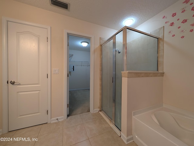 bathroom with tile patterned flooring, a textured ceiling, and separate shower and tub