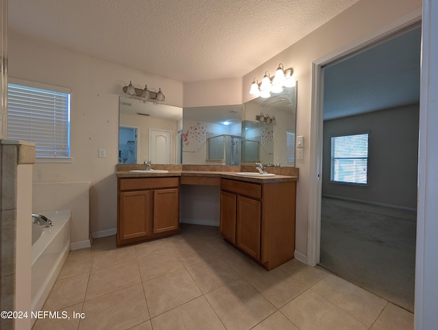 bathroom featuring a textured ceiling, vanity, shower with separate bathtub, and tile patterned floors