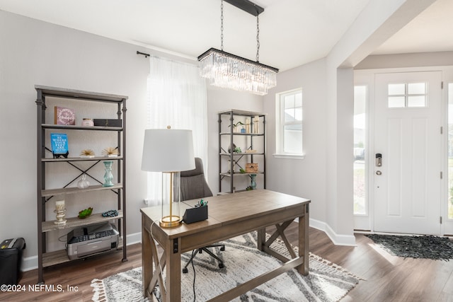 office space featuring a wealth of natural light, dark hardwood / wood-style floors, and a chandelier