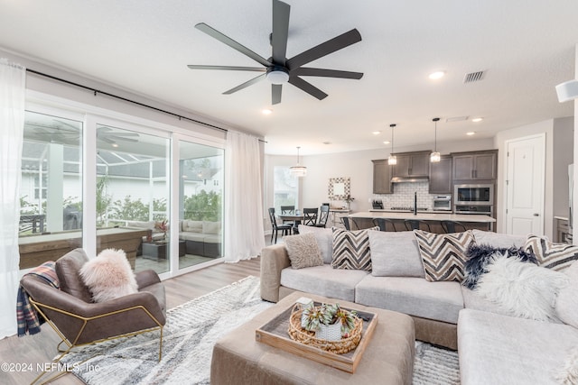 living room featuring light wood-type flooring and ceiling fan