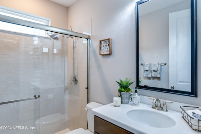 bathroom with walk in shower, vanity, and toilet