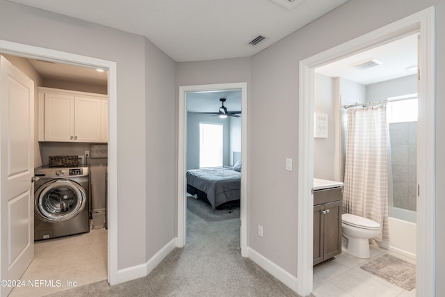 laundry room featuring plenty of natural light, light carpet, cabinets, and washer / dryer