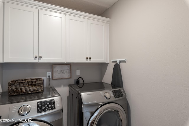 laundry room featuring cabinets and washer and clothes dryer