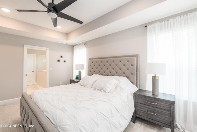 bedroom with multiple windows, light colored carpet, and ceiling fan