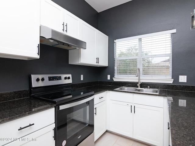 kitchen with white cabinets, stainless steel electric stove, dark stone countertops, and sink