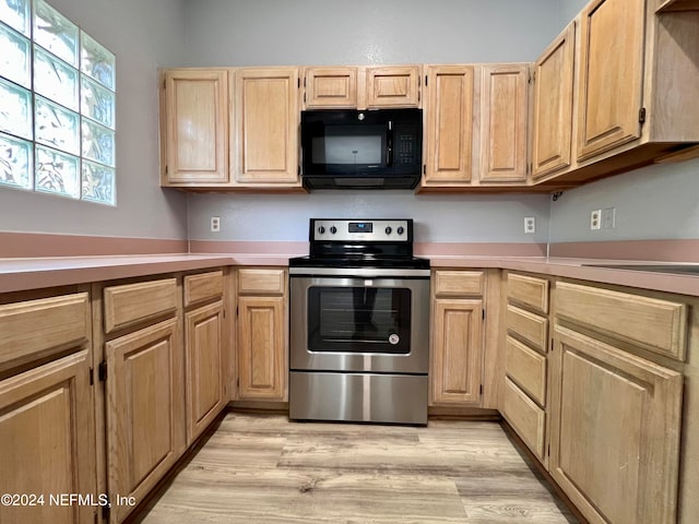 kitchen with stainless steel electric range, light hardwood / wood-style flooring, and light brown cabinets