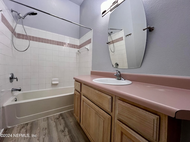 bathroom with tiled shower / bath combo, vanity, and hardwood / wood-style flooring