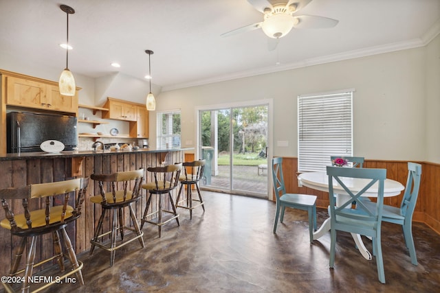 kitchen with light brown cabinets, ceiling fan, backsplash, black refrigerator, and pendant lighting