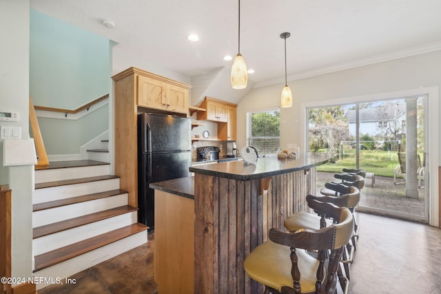 kitchen featuring black refrigerator, light brown cabinets, decorative light fixtures, and crown molding