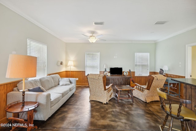 living room featuring wood walls, ceiling fan, and crown molding