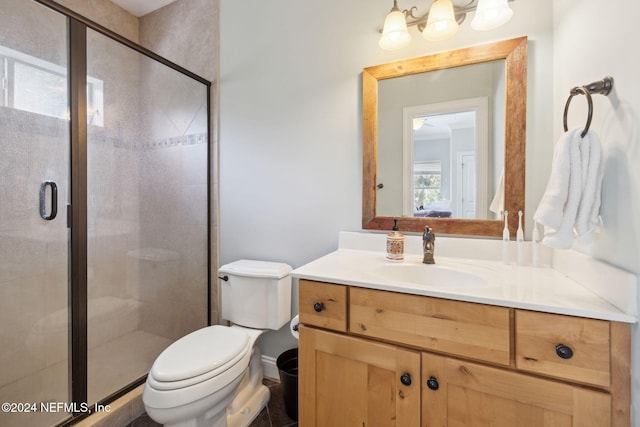 bathroom with vanity, toilet, and a shower with shower door