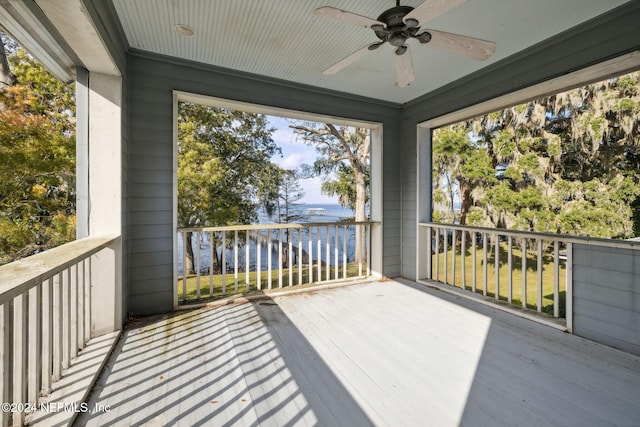 wooden deck with ceiling fan and a water view