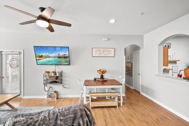 dining room with a textured ceiling, light hardwood / wood-style floors, and ceiling fan