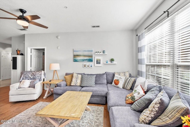 living room with light wood-type flooring and ceiling fan