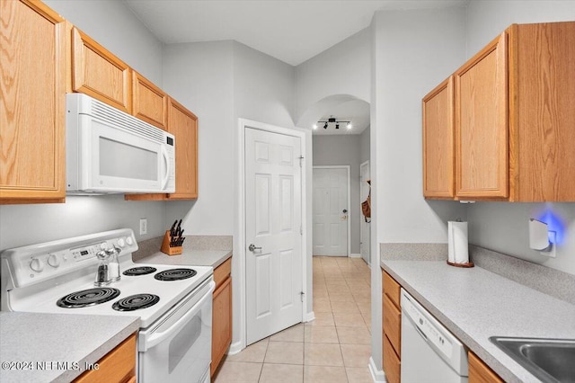 kitchen featuring light tile patterned floors, white appliances, and light brown cabinetry