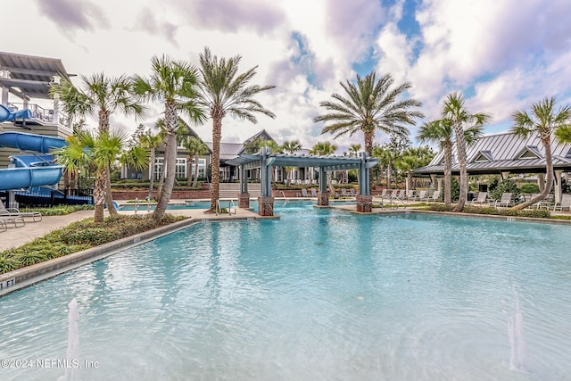 view of pool with a pergola and a water slide