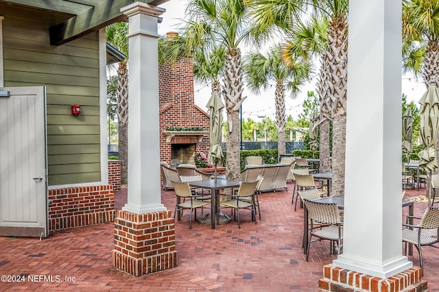 view of patio with an outdoor brick fireplace