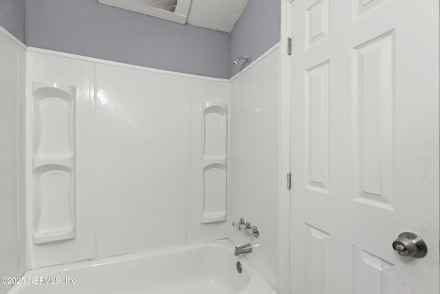 bathroom featuring a textured ceiling and shower / washtub combination