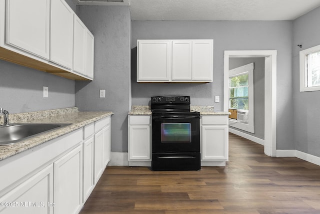 kitchen featuring white cabinets, light stone counters, sink, and black electric range oven