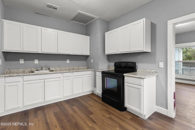 kitchen with black range with electric stovetop, sink, and white cabinetry