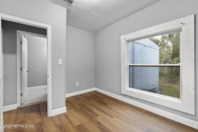 unfurnished bedroom featuring a textured ceiling and hardwood / wood-style floors
