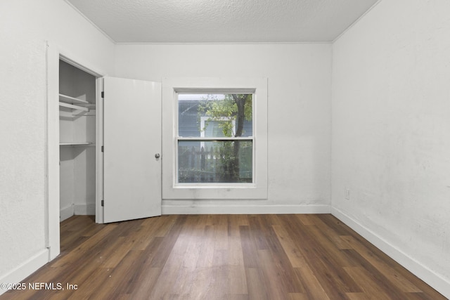 unfurnished bedroom with dark hardwood / wood-style floors and a textured ceiling