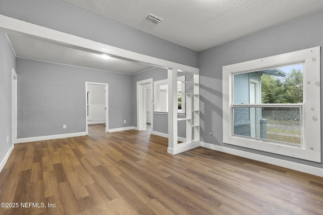 unfurnished room with a textured ceiling and hardwood / wood-style flooring