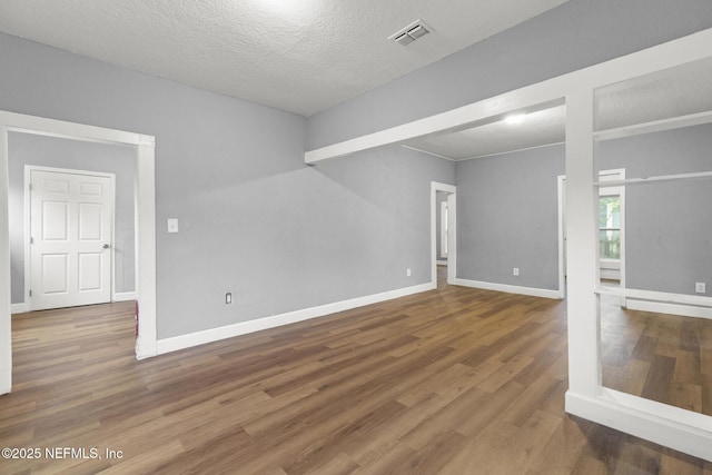 unfurnished room featuring a textured ceiling and hardwood / wood-style floors