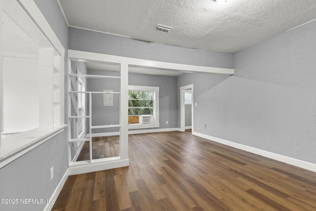 unfurnished room featuring dark hardwood / wood-style flooring and a textured ceiling