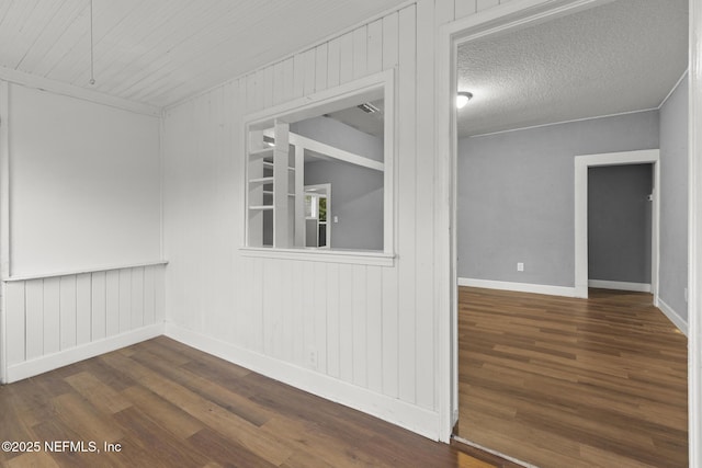 empty room featuring dark hardwood / wood-style flooring and a textured ceiling
