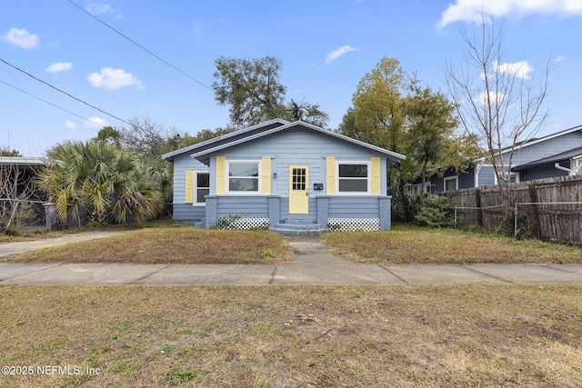 bungalow-style home with a front yard