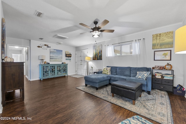 living room with a textured ceiling, dark hardwood / wood-style flooring, ceiling fan, and crown molding