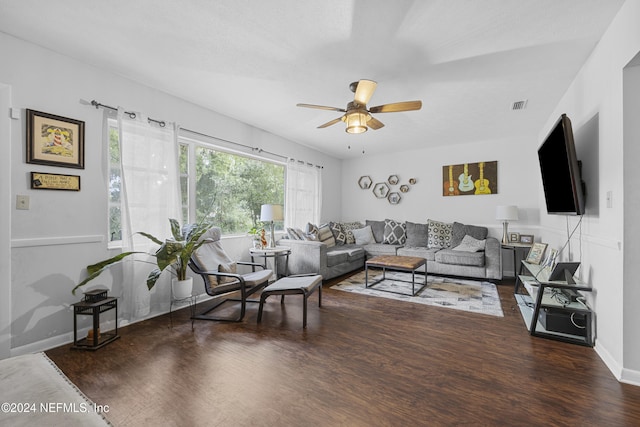 living room featuring dark wood-type flooring and ceiling fan