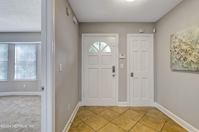 tiled foyer featuring a textured ceiling and plenty of natural light