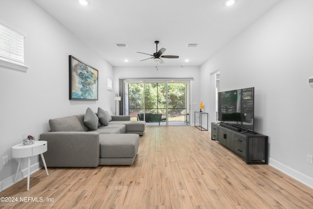 living room with light hardwood / wood-style flooring and ceiling fan