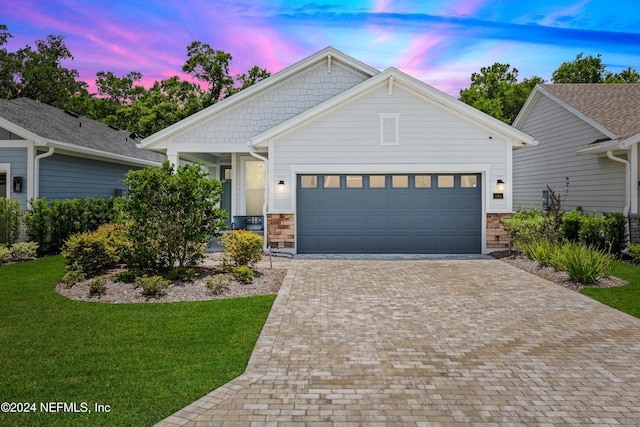 view of front of home featuring a garage and a yard