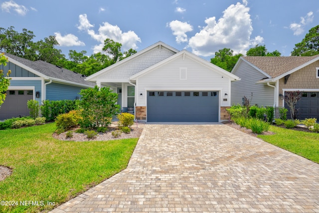 craftsman-style house featuring a front lawn and a garage