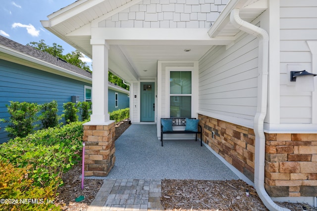 view of exterior entry with a porch